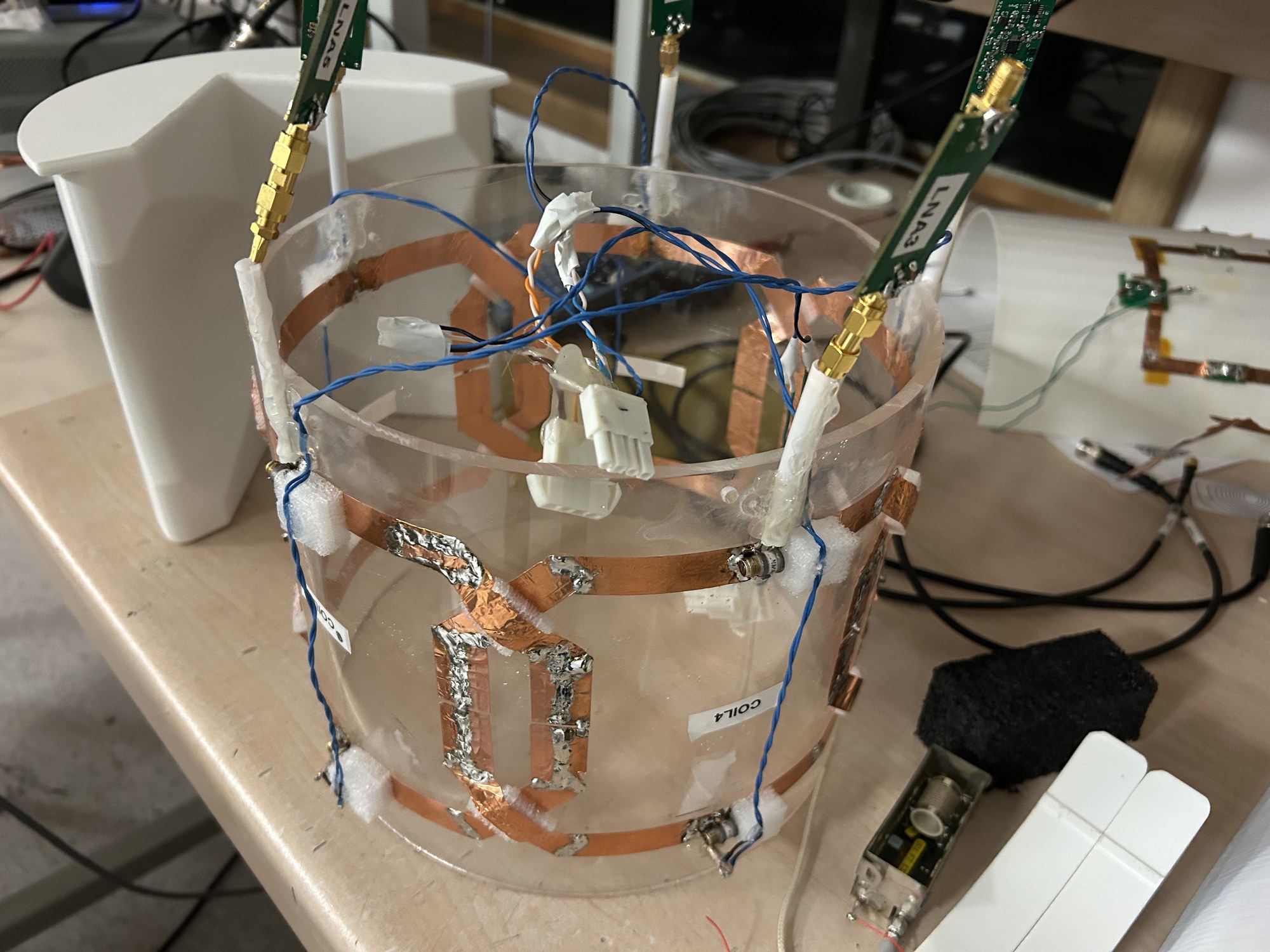 Acrylic cylinder carrying copper receive loops, with preamplifier boards mounted above it